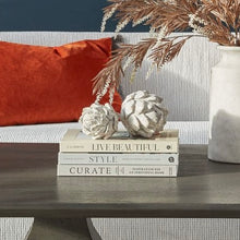 Load image into Gallery viewer, Decorative books on a table with decorative white artichokes in a home setting