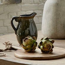 Load image into Gallery viewer, Faux artichoke with realistic texture displayed on a wooden board next to a ceramic pitcher and vase.