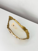 Load image into Gallery viewer, Hand poured shell candle in a gold-tipped oyster shell with a flickering flame.