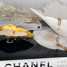 Load image into Gallery viewer, Shell candle on a decorative table with books and gold chain accent, showcasing its eco-friendly design.
