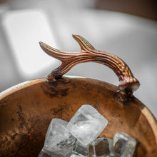 Carica l'immagine nel visualizzatore di Gallery, Wine cooler with antiqued brass finish and antler handle, filled with ice cubes for chilling beverages.
