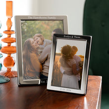 Charger l'image dans la galerie, Personalised silver plated photo frame showcasing family and wedding portraits in two sizes on a wooden table.
