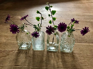 A set of four little bottle vases