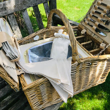 Carica l'immagine nel visualizzatore di Gallery, Open picnic hamper showcasing utensils and cooler compartment on a wooden bench.
