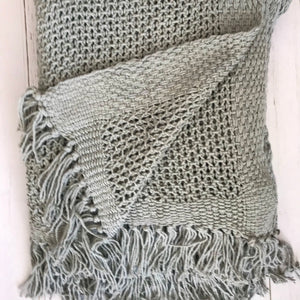 Open knit tasseled throw